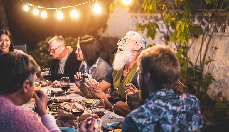 Happy group of friends having fun at dinner in Italy