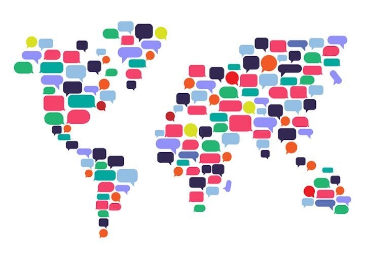 Colorful speech bubbles arranged in the shape of a world map, representing multilingual communication and global interpretation services.