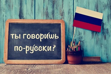 Chalkboard with Russian phrase 'Do you speak Russian?' and flag