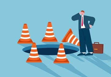 cartoon of businessman confused by pitfalls despite warning signs, symbolizing translation errors
