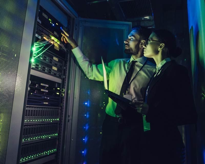 two team members inspecting computer