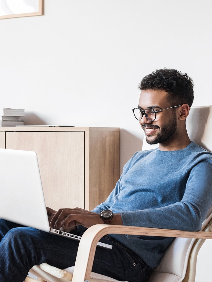 man in chair looking at laptop