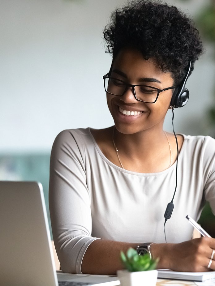 woman smiling while looking at- aptop