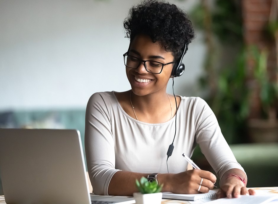 woman smiling while looking at laptop