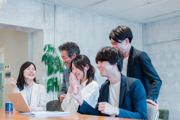 japanese business people gathered around conference desk