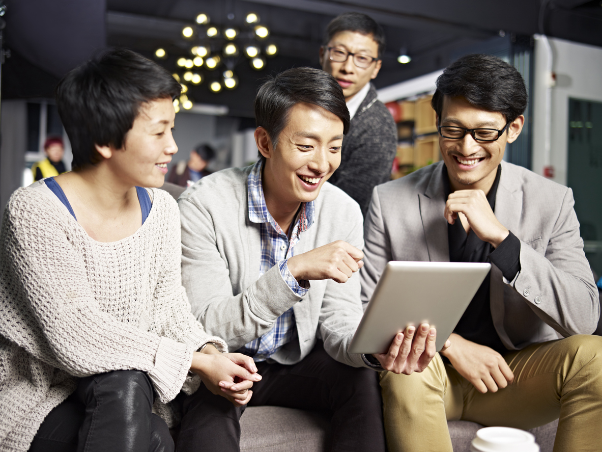 group of Koren men reviewing translated content on a ltablet